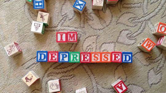 Children's letter blocks arranged to spell out "I'M DEPRESSED"